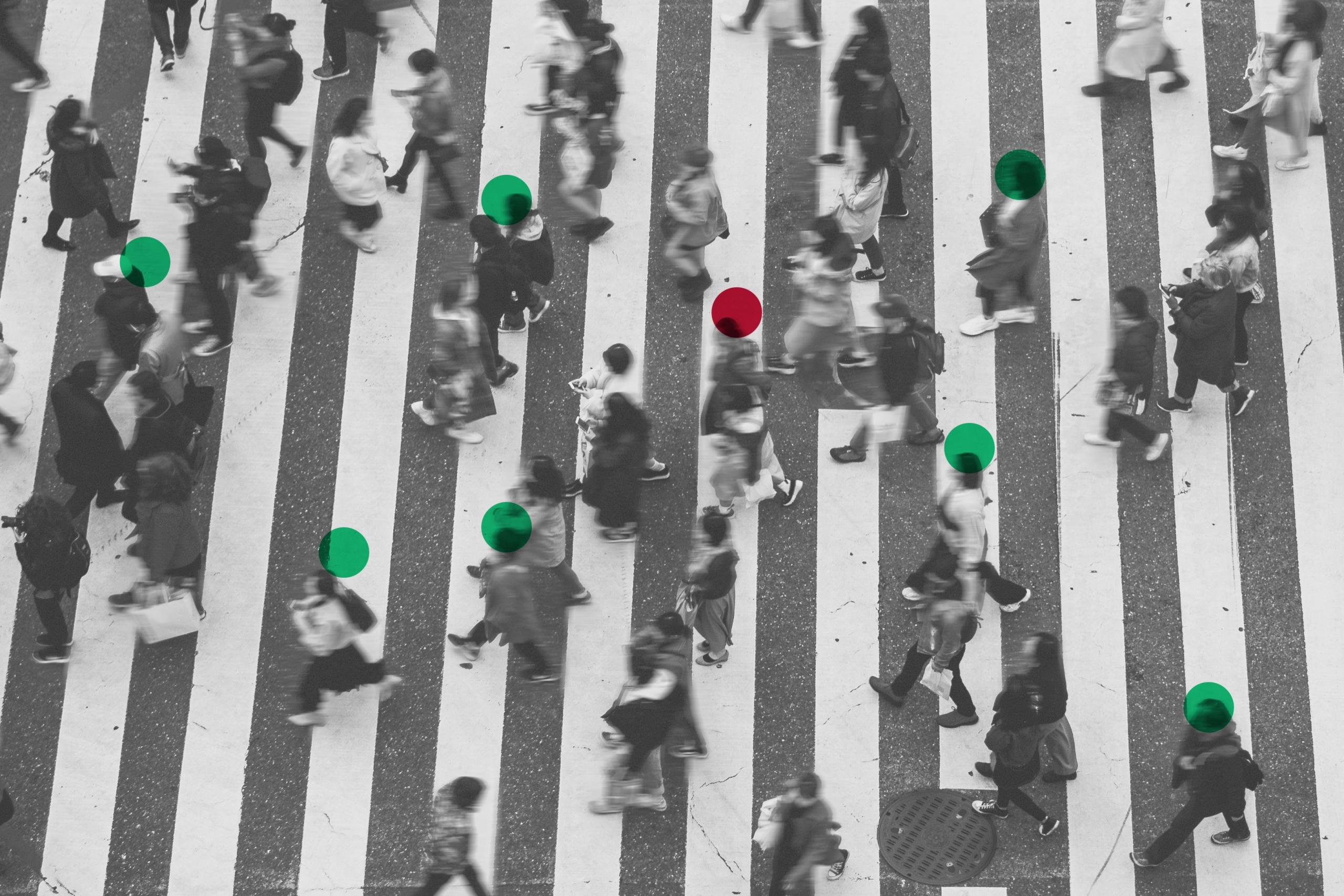 vista cenital de personas cruzando las lineas peatonales de la pista